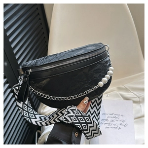Close-up of black pleated texture chest bag with pearl chain and woven shoulder strap