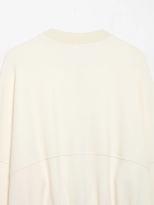Vue arrière d'une veste en maille beige avec col rond côtelé et détails de couture