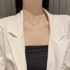Detail of a 925 sterling silver mesh woven necklace on a model wearing a white blazer