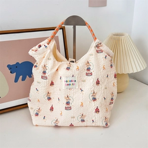 Detail of cream pleated canvas tote with circus print and woven orange rope handles