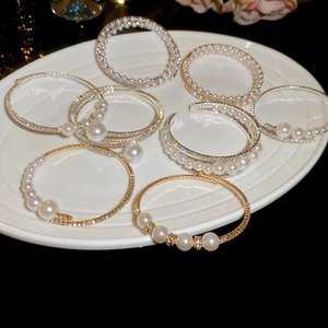 Detailed collection of pearl and rhinestone bangles in gold and silver plating