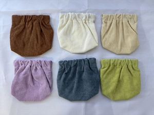 Detail view of corduroy baby bloomer pants in six various colors with ribbed texture