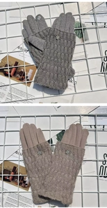 Detail view of gray and camel knitted convertible gloves with rhinestone flower accents