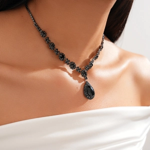 Close-up of vintage black rhinestone waterdrop necklace on a model wearing a white dress