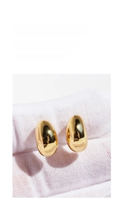 Macro shot of minimalist gold teardrop earrings with a polished mirror finish surface