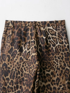 Dettaglio dei pantaloni a vita alta con stampa leopardata, passanti e trama del tessuto