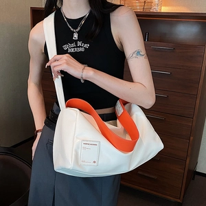 Minimalistische weiße Umhängetasche mit orangen Kontrasten an einem weiblichen Model