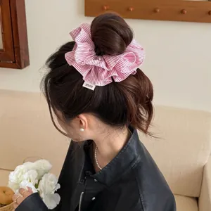 Pink and white striped double-layered scrunchie for bun hairstyles with woven label detail