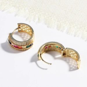 Detail of gold hoop earrings featuring multi-color rainbow stones and white cubic zirconia