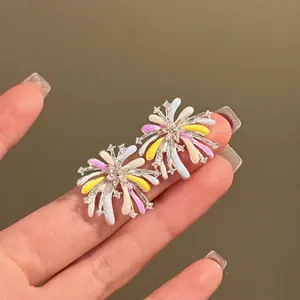 Handheld display of colorful fireworks-shaped enamel earrings with zircon accents