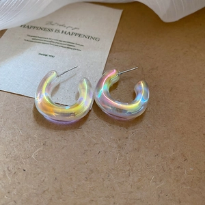 Detailed view of iridescent acrylic C-shape hoop earrings on a decorative card