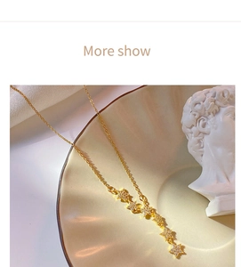 Detail view of gold star tassel necklace with sparkling zircon stars on ceramic tray