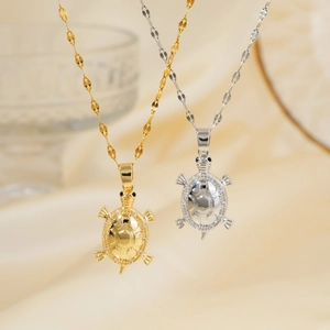Elegant gold and silver turtle pendant necklaces with zircon inlay on silk background
