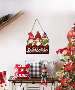 Close-up of three Christmas gnomes on a wooden Welcome sign with festive home decor