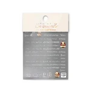 Close-up of Christmas nail art stickers featuring Santa Claus and winter letter patterns