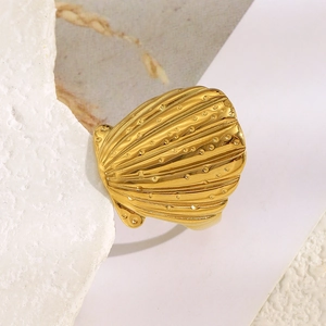 Makro-Detail des vergoldeten Muschelrings mit feinen Rillen und kleinen Kugeln