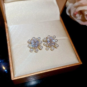 Detailed macro view of 14k gold plated flower stud earrings with zircon and pearls