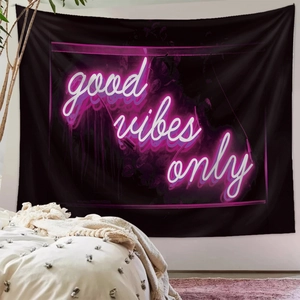 Detailed view of Good Vibes Only neon lettering on a black wall tapestry hanging in a bedroom