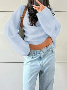Detailed view of light blue knitted sweater with long sleeves and short length cut