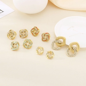 Crossed gold earrings with sparkling crystals and colorful enamel in geometric designs