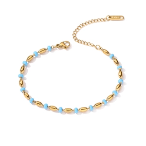 Detailed shot of Tree of Life bracelet featuring gold steel links and blue beads