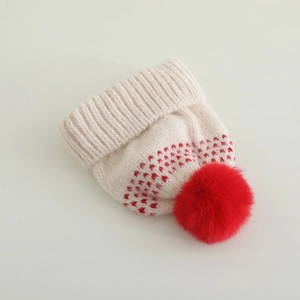 Détail de la maille côtelée et du pompon rouge sur le bonnet d'hiver pour enfants