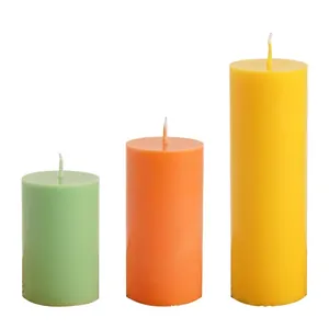 Three-piece set of cylindrical pillar candles in green, orange, and yellow matte finish