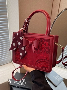 Elegant red lace embroidered handbag with bow detail and heart pattern silk scarf handle