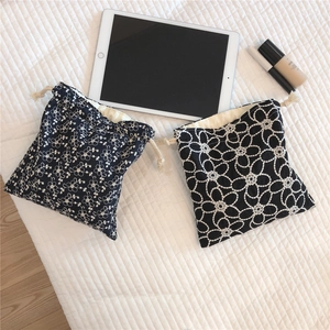 Detail of black cotton drawstring bags with floral embroidery and natural cotton cords