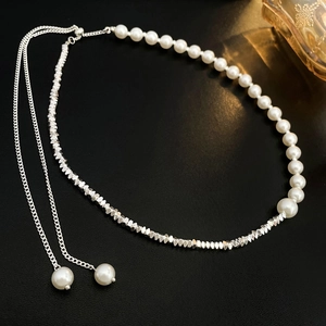 Elegant pearl and silver bead tassel necklace on black leather texture background