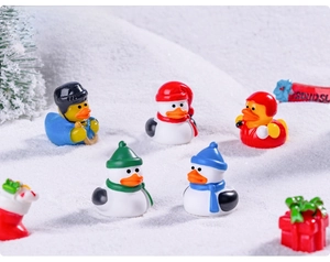 Close-up of winter sports duck figurines and snowman miniatures in a snowy DIY setting