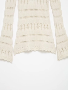 Detail showing knit hollow texture and scalloped hem on the off-shoulder top