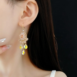 Close-up of ethnic style chandelier earrings with zircon water drops and champagne gold finish
