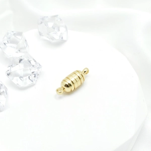 Golden barrel magnetic jewelry clasp with rings for pearl necklaces on white silk