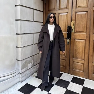 Women's long brown wool coat with lapel collar and double-breasted buttons in street style