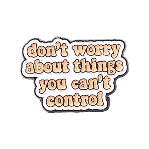 Pin's en émail avec texte orange disant don't worry about things you can't control