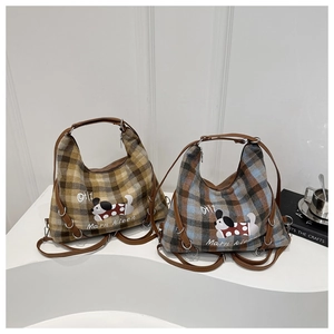 Detail of checkered canvas tote bags with cute dog illustrations and durable handles