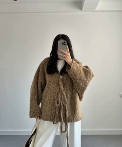 Detail of fuzzy brown oversized knit cardigan showing plush texture and tie closure