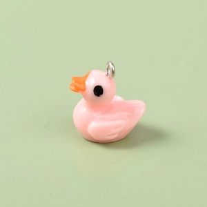 Close-up of a pink resin mini duck charm with a metal loop for DIY jewelry making