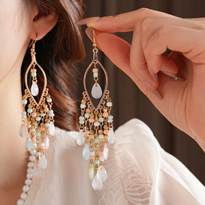 Bohemian dangle earrings with acrylic beads and waterdrop tassels worn by a model