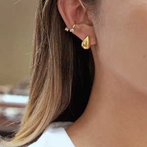 Elegant gold-tone teardrop earrings and zircon ear cuff set shown on a model