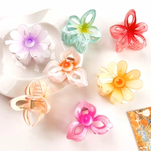 Macro shot of colorful translucent resin flower hair claws with golden metal springs