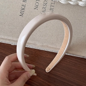 Détail d'un serre-tête beige épais avec finition brillante et doublure antidérapante