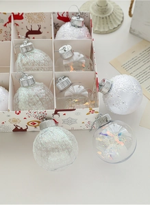 Detail of assorted champagne Christmas ornaments in a grid box with reindeer motifs