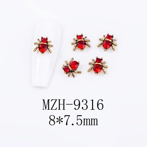 Detailed close-up of 5 red rhinestone spider alloy nail charms in vintage gold finish