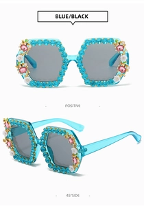 Detail view of square rhinestone sunglasses in blue with floral accents and grey lenses