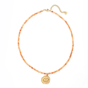 Close-up of vintage sun moon copper necklace with orange natural stones and evil eye charm