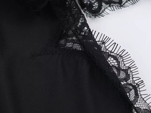 Nahaufnahme der filigranen Wimpernspitze am schwarzen Samtkleid mit weicher Textur