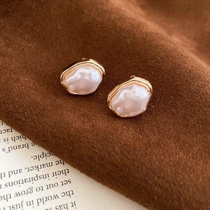 Detail of French vintage irregular pearl ear cuff with gold metal edging on velvet