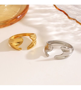 Detailed view of irregular wavy stainless steel rings in gold and silver finish